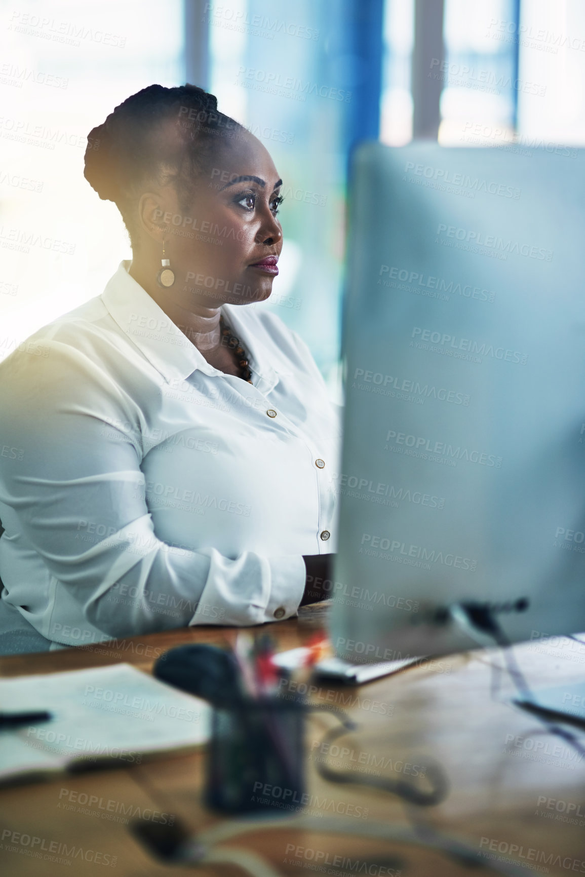 Buy stock photo Shot of a focussed businesswoman working behind her computer in the office