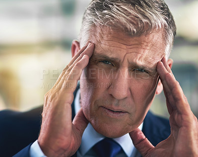 Buy stock photo Portrait of a tense businessman holding his head in the office