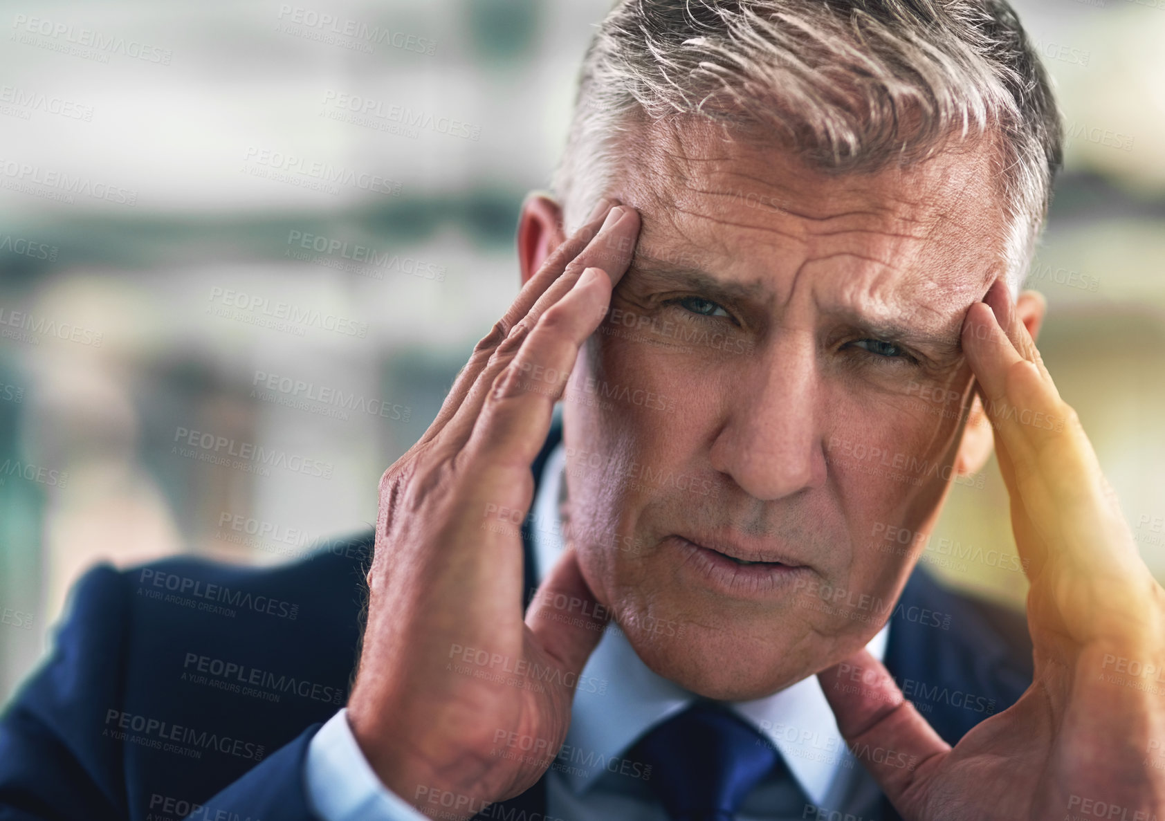 Buy stock photo Portrait of a tense businessman holding his head in the office