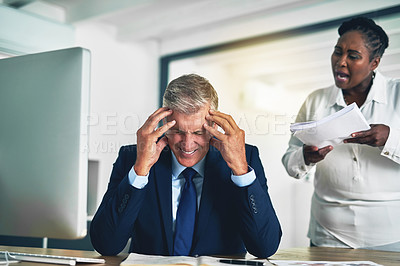 Buy stock photo Shot of an angry businesswoman berating her colleague while he sits at his desk