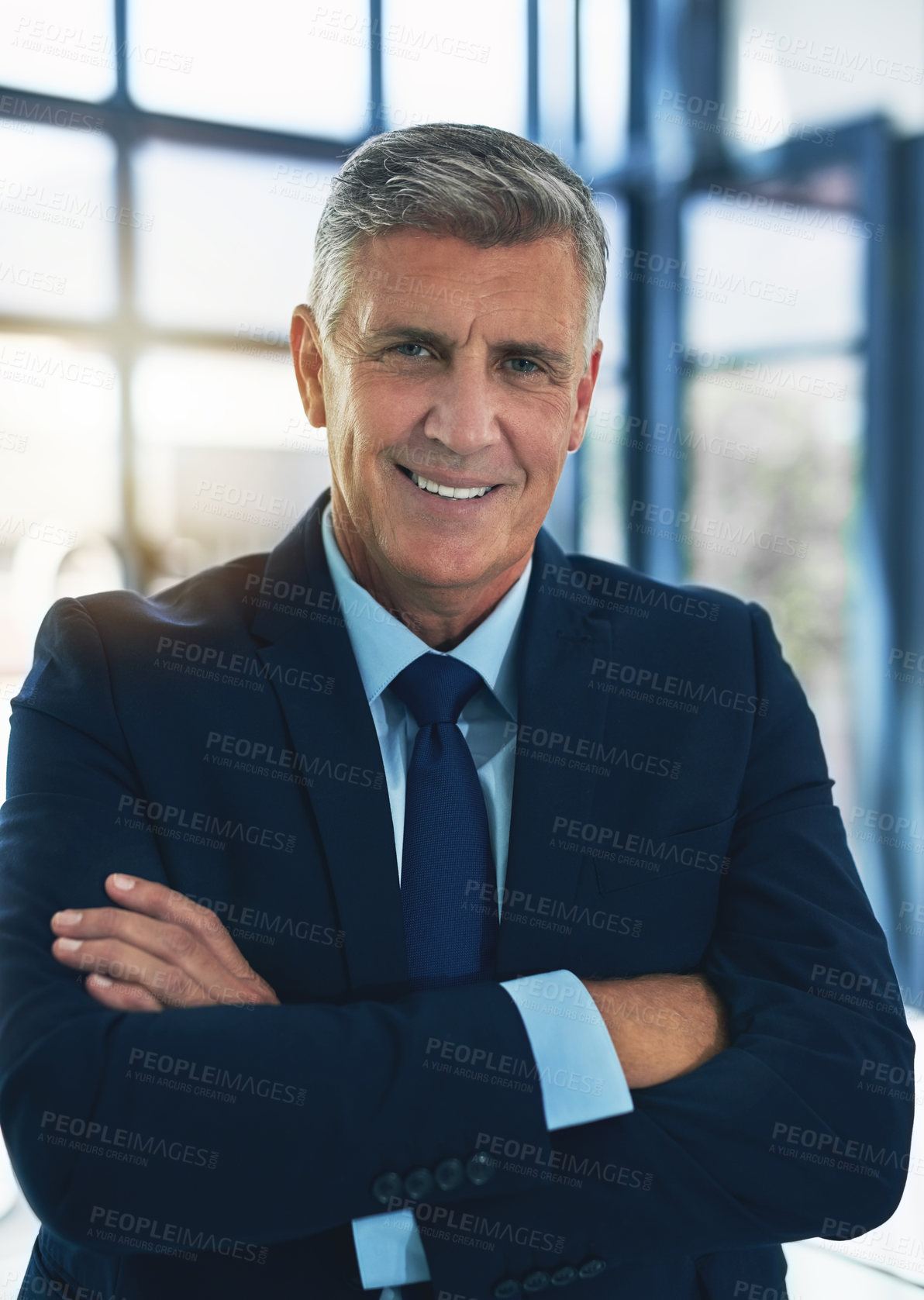 Buy stock photo Portrait of a confident businessman posing with his arms crossed in the office