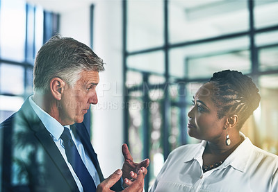 Buy stock photo Shot of two focussed businesspeople brainstorming together in the office