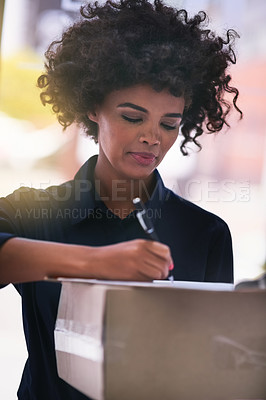 Buy stock photo Shot of a businesswoman signing for a package delivered by a courier in her office