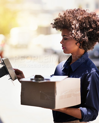 Buy stock photo Shot of a focused young delivery woman out on a delivery