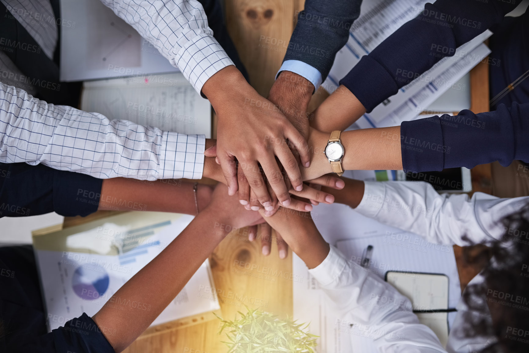 Buy stock photo High angle shot of a group of businesspeople putting their hands in a pile in the office