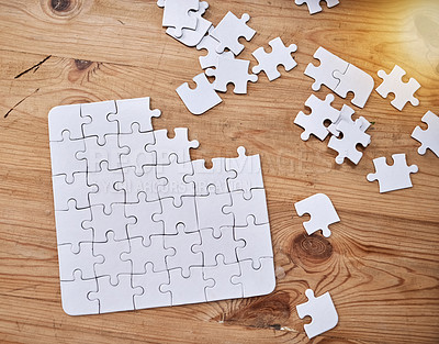 Buy stock photo High angle shot of an unfinished jigsaw puzzle lying on a wooden table