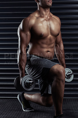 Buy stock photo Cropped shot of an unrecognizable young man working out with dumbbells