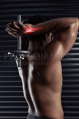 Buy stock photo Rearview shot of an athletic young man working out with a dumbbell