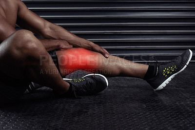 Buy stock photo Shot of an unrecognizable man sitting down with a knee injury during a workout
