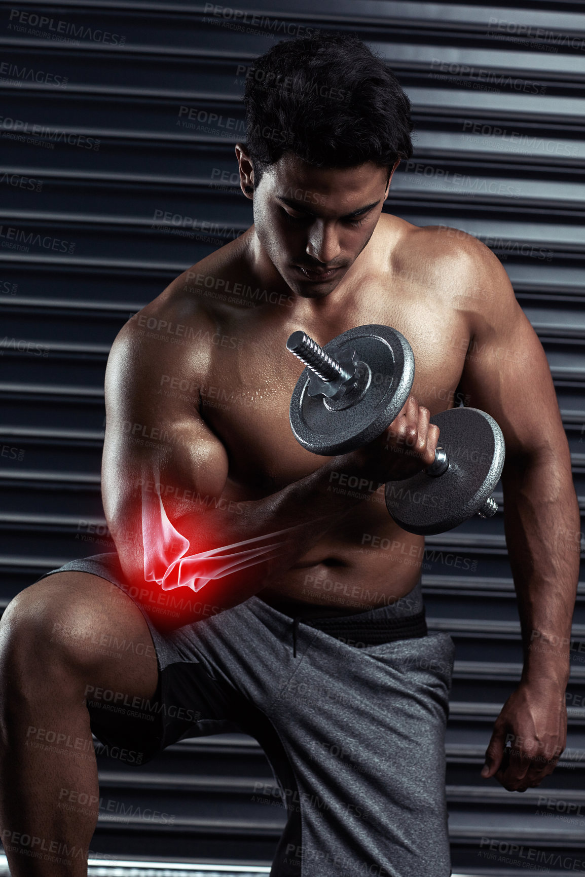 Buy stock photo Cropped shot of an athletic young man working out with a dumbbell