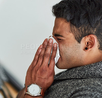 Buy stock photo Profile, hand and blowing nose with a man using a tissue closeup in his home for relief from allergy symptoms. Face, sick with a cold or flu and a young person sneezing due to a virus or hay fever