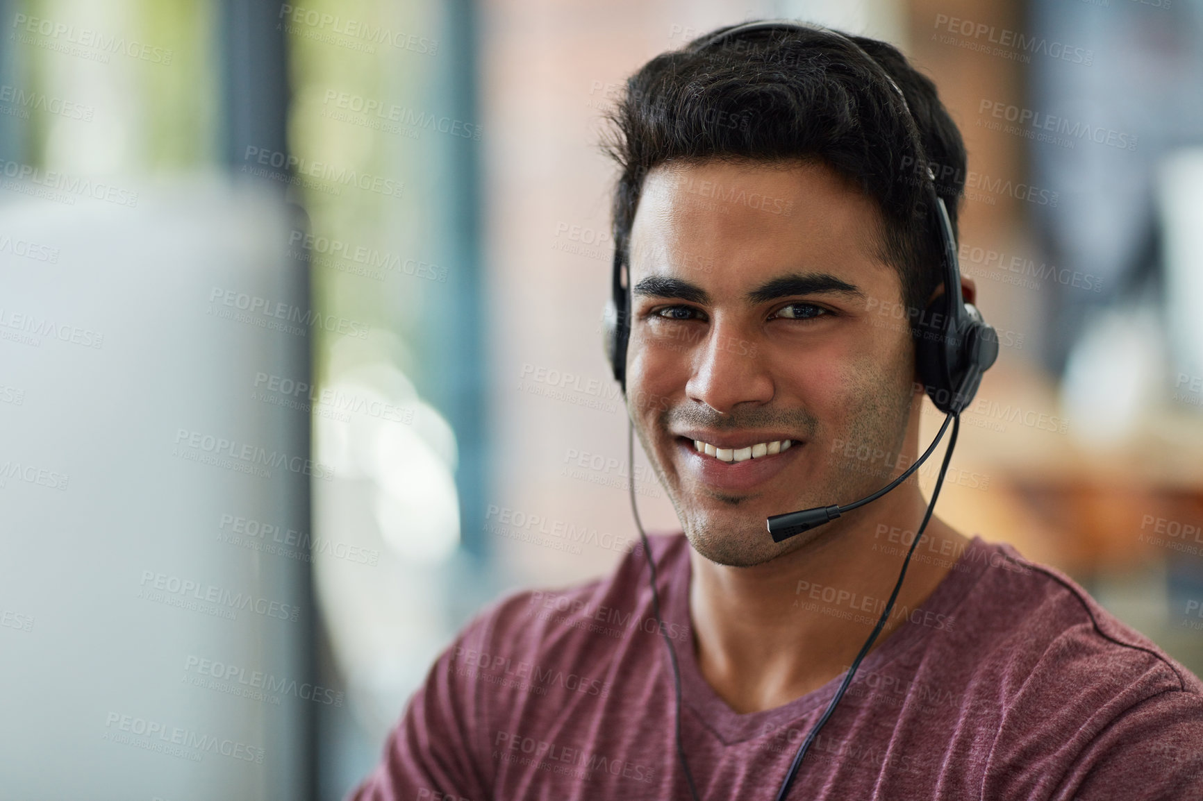 Buy stock photo Shot of a young call centre agent working at his desk