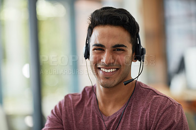 Buy stock photo Shot of a young call centre agent working at his desk