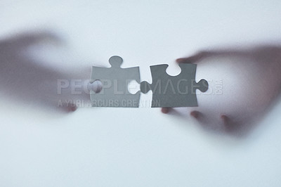 Buy stock photo Defocussed shot of two unrecognizable businesspeople holding two puzzle pieces together