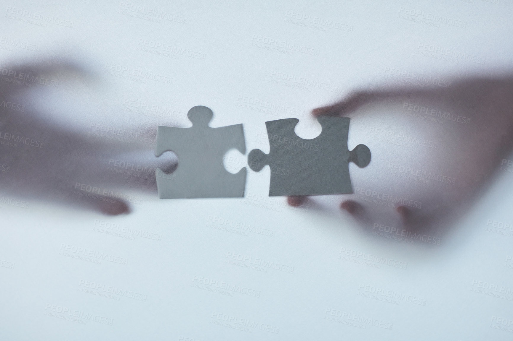 Buy stock photo Defocussed shot of two unrecognizable businesspeople holding two puzzle pieces together