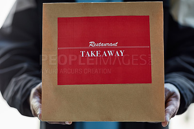 Buy stock photo Cropped shot of an unidentifiable delivery man holding a a restaurant takeaway