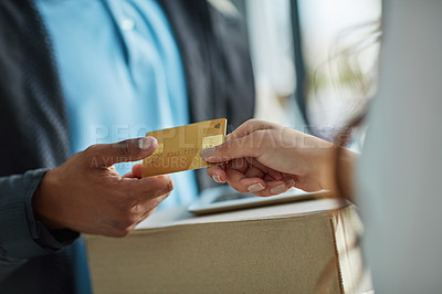 Buy stock photo Cropped shot of a customer using a credit card to pay for a delivery made by a courier