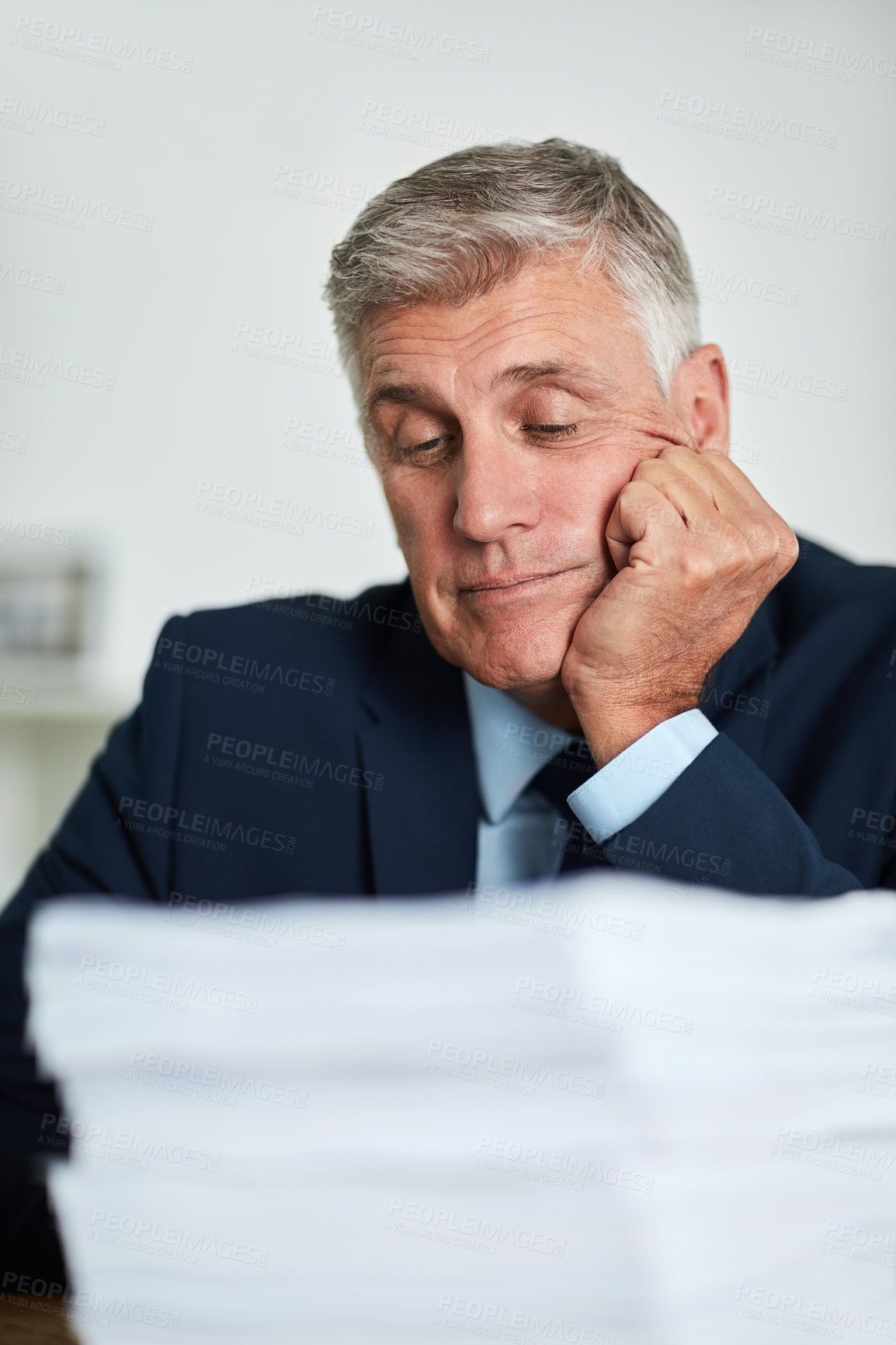 Buy stock photo Cropped shot of a mature businessman looking bored at work