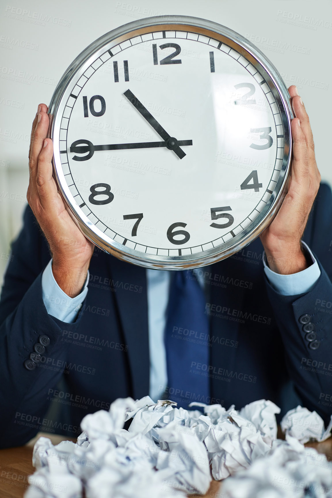 Buy stock photo Shot of an unrecognizable businessman holding a large clock in front of his face