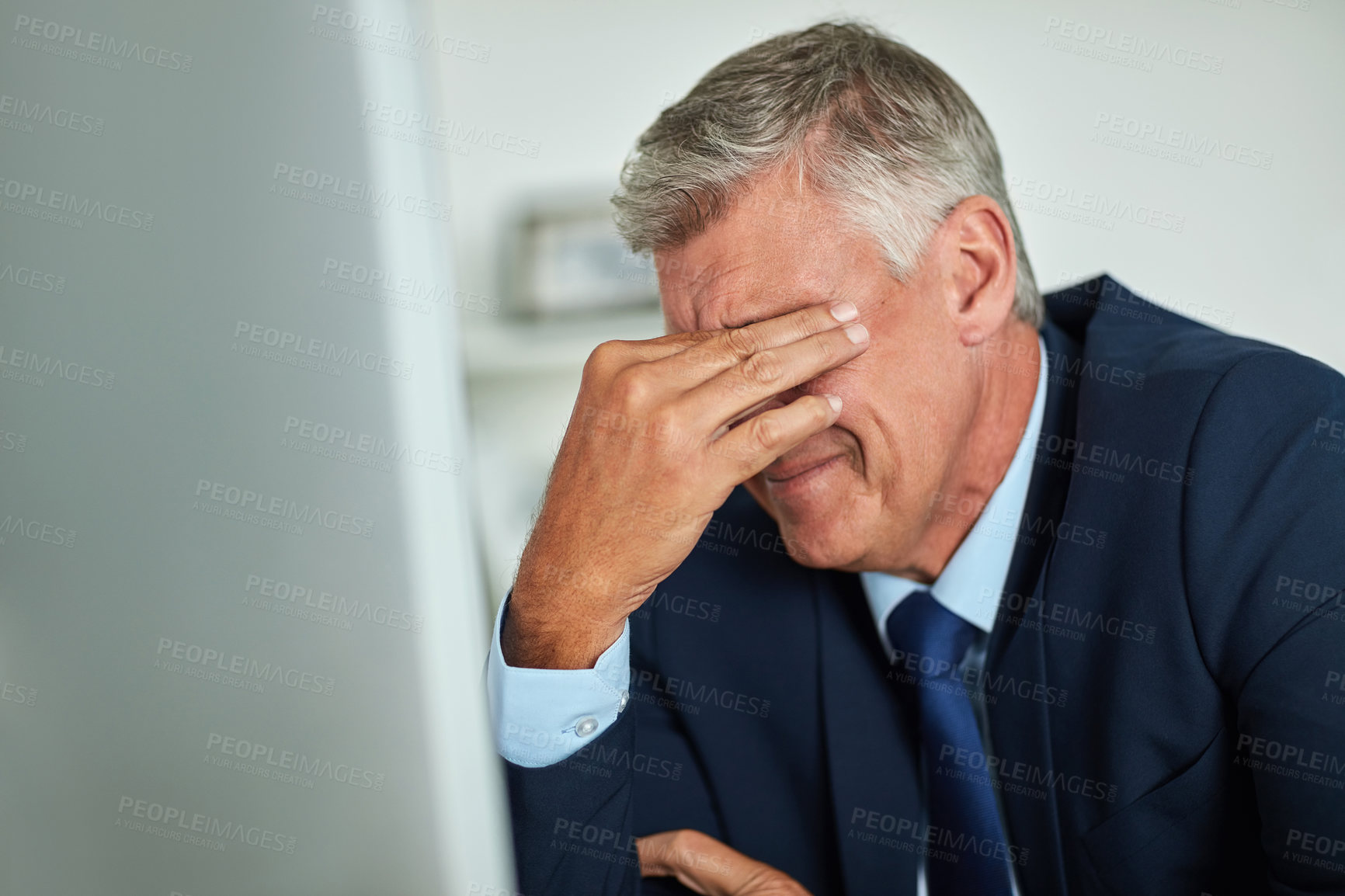 Buy stock photo Shot of a mature businessman looking frustrated while working on his computer in the office