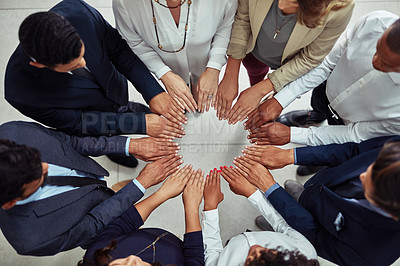 Buy stock photo High angle shot of a group of businesspeople joining their hands together in unity