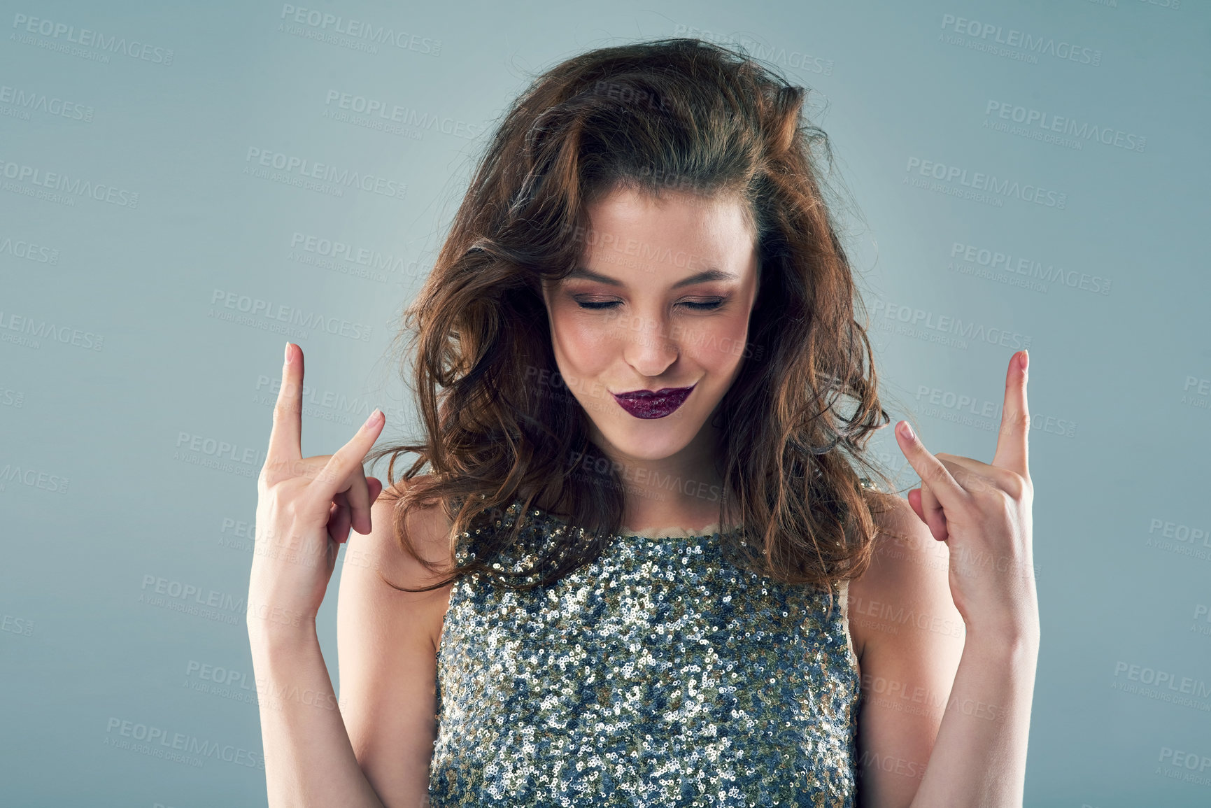 Buy stock photo Studio shot of a young woman making a hand gesture against a grey background