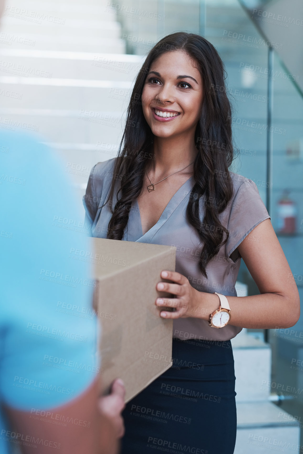 Buy stock photo Cropped shot of a businesswoman accepting a package from a courier in her office