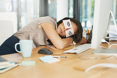 Buy stock photo Shot of a tired businesswoman napping at her desk with adhesive notes on her eyes