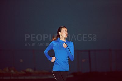 Buy stock photo Cropped shot of a young woman out running at night time