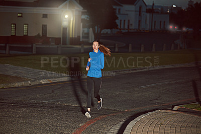 Buy stock photo Cropped shot of a young woman out running at night time