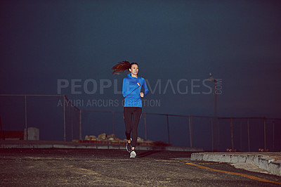 Buy stock photo Cropped shot of a young woman out running at night time