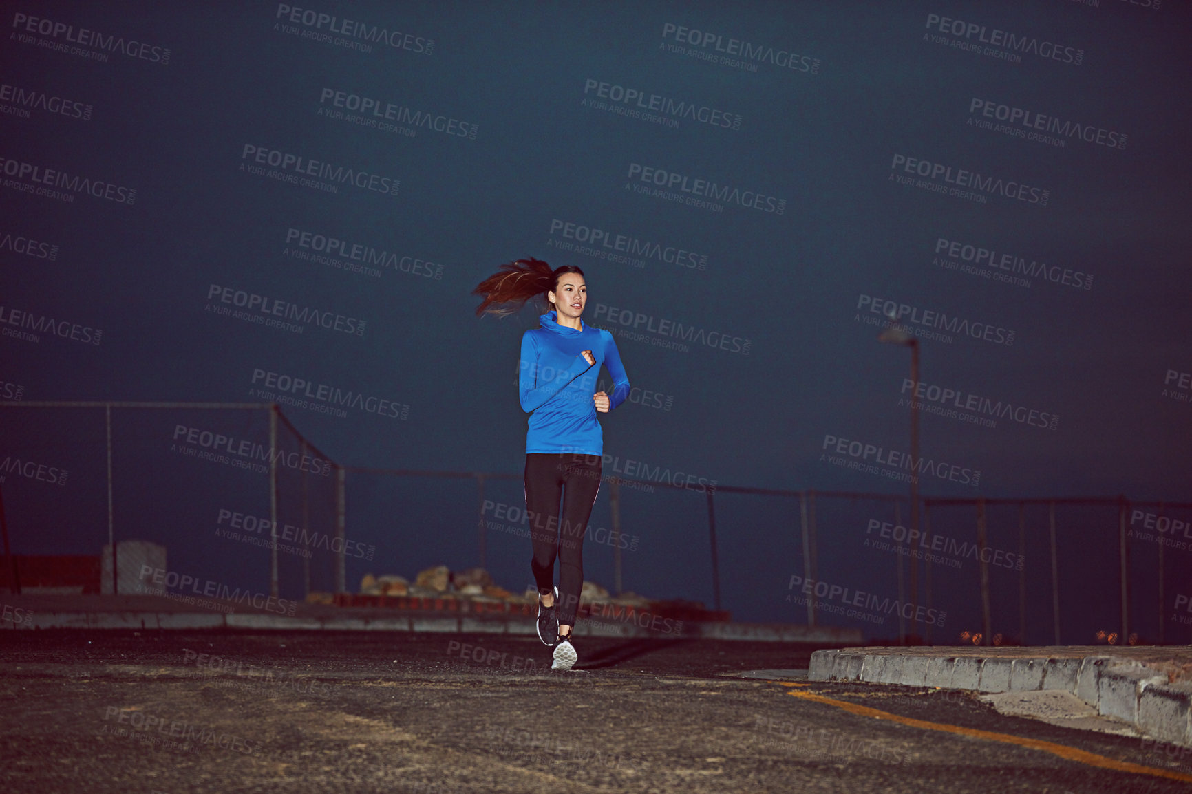 Buy stock photo Cropped shot of a young woman out running at night time