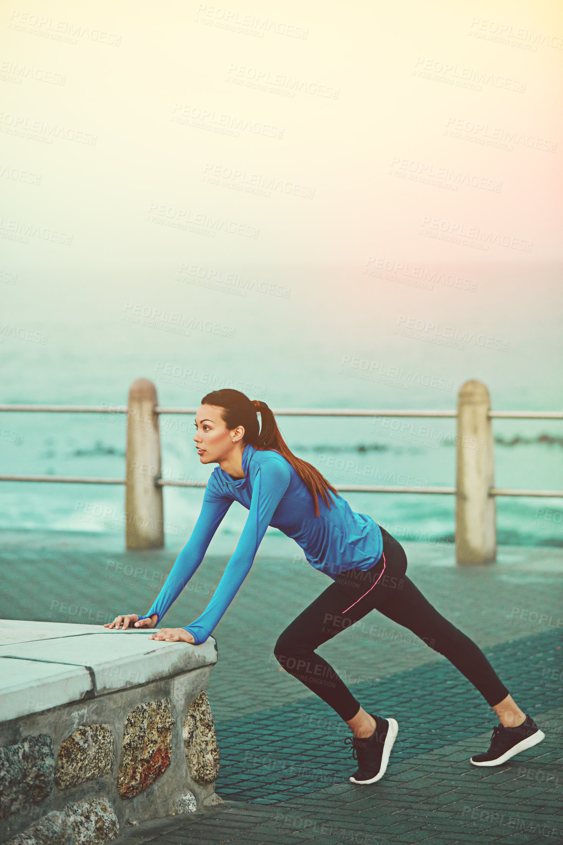 Buy stock photo Shot of a sporty young woman stretching before her run