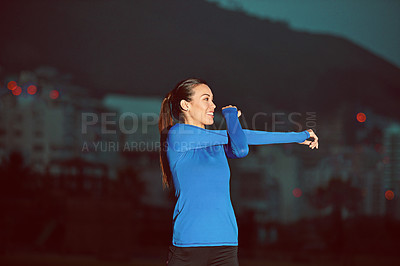 Buy stock photo Shot of a sporty young woman stretching before her run