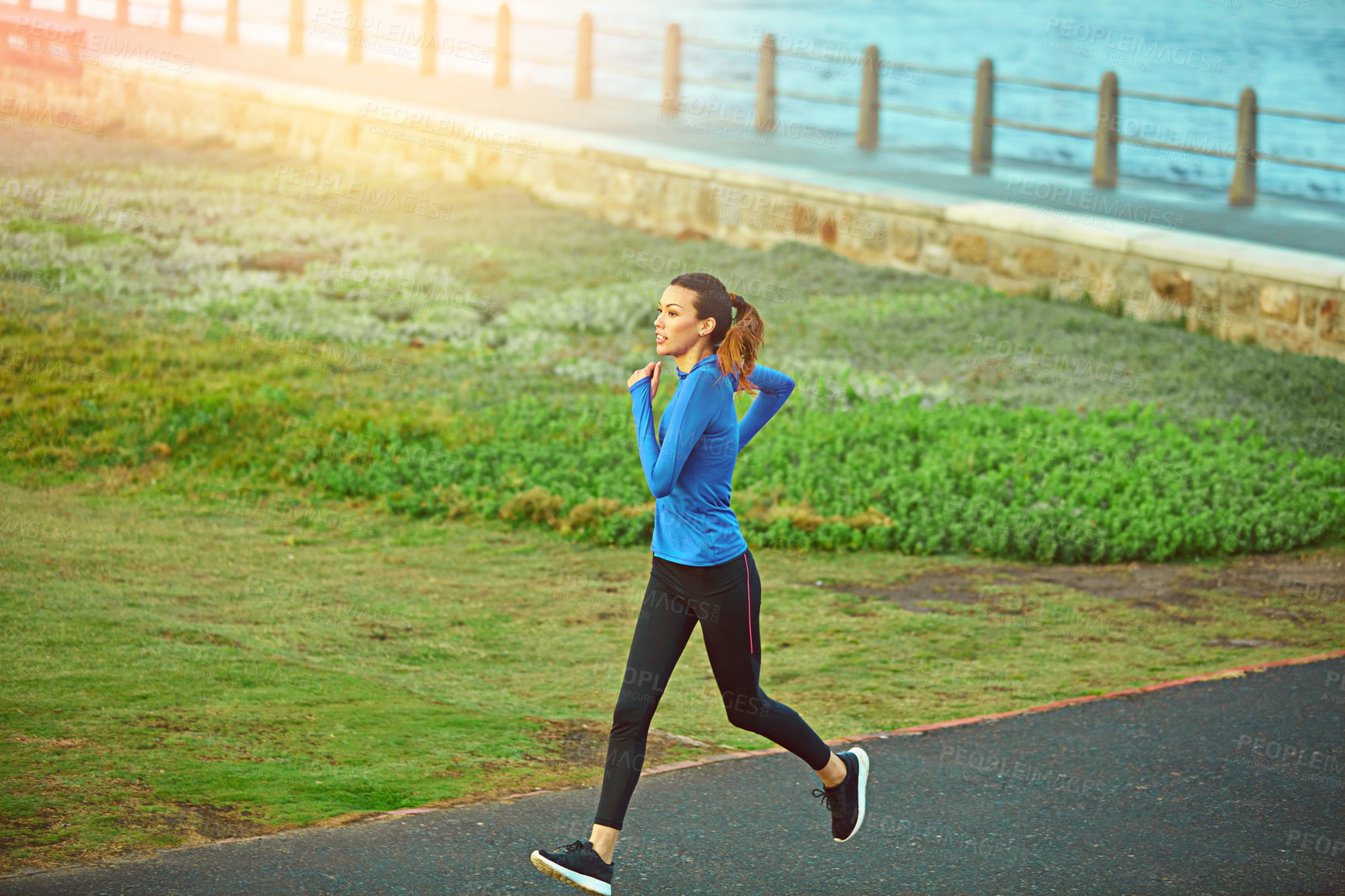 Buy stock photo Shot of a sporty young woman out for a run