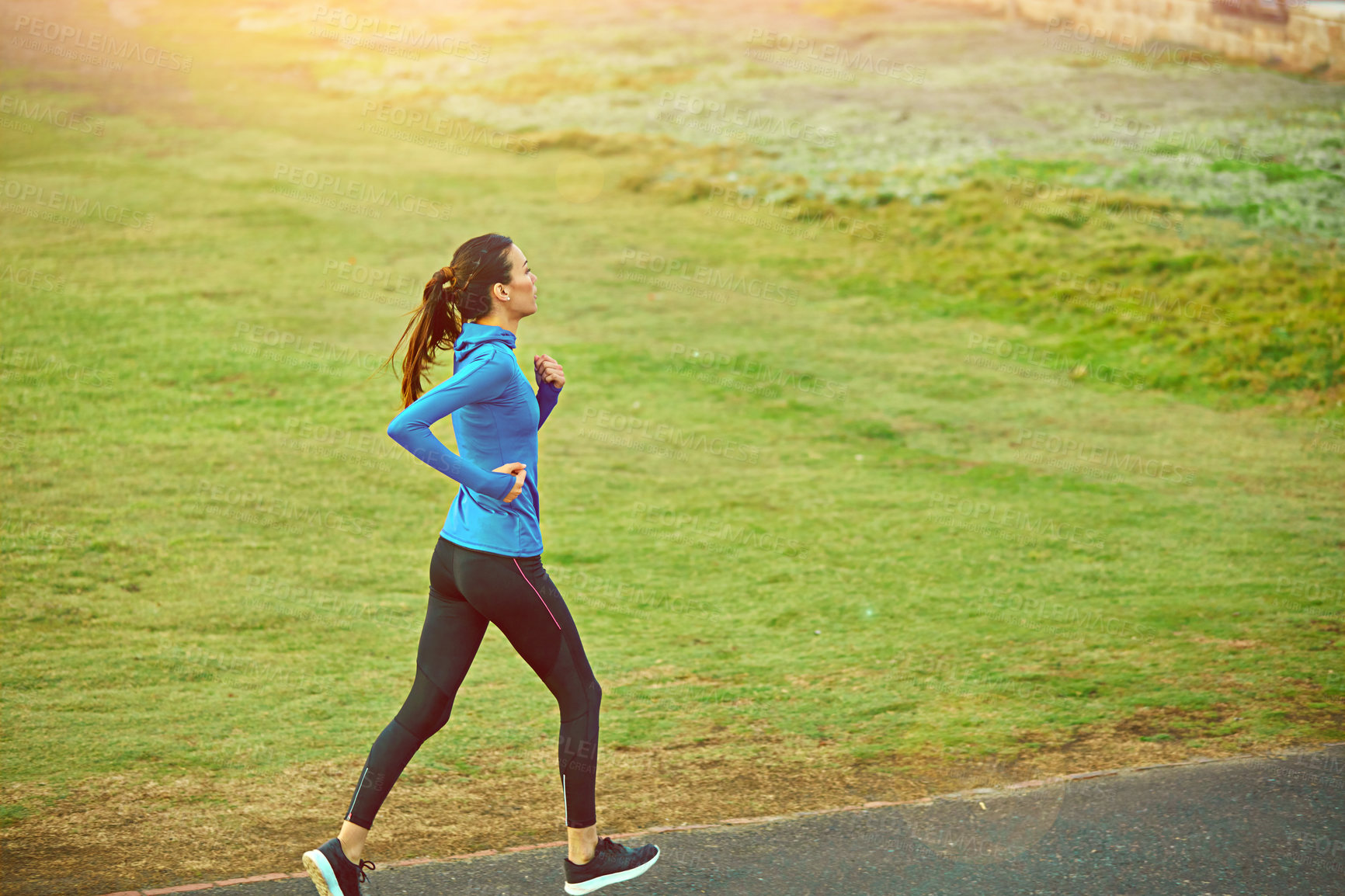 Buy stock photo Shot of a sporty young woman out for a run