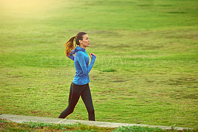 Buy stock photo Shot of a sporty young woman out for a run