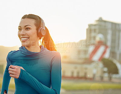 Buy stock photo Shot of a sporty young woman out for a run in the city
