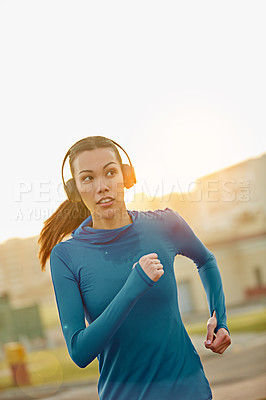 Buy stock photo Shot of a sporty young woman out for a run in the city