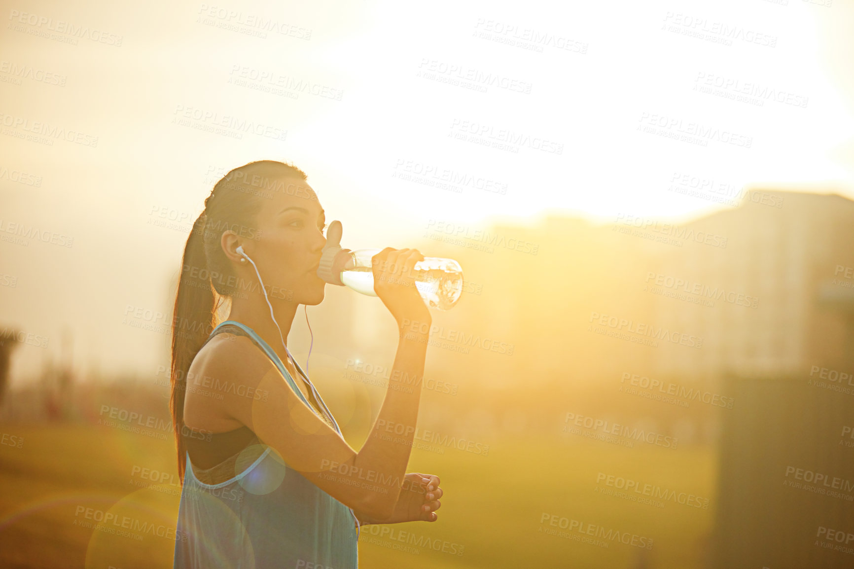 Buy stock photo Woman, runner and drinking water with earphones for exercise with audio, subscription or detox in city. Girl, person and athlete at training, workout or sound for music streaming with health on road