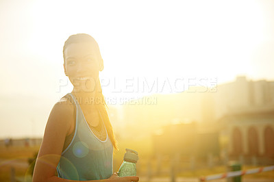 Buy stock photo Shot of a young woman drinking water after her run