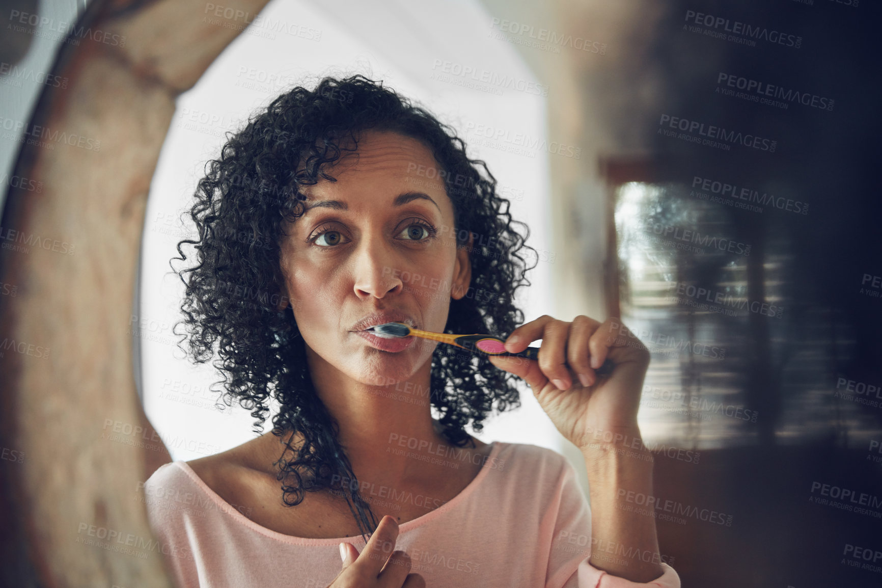 Buy stock photo Woman, cleaning and brushing teeth in mirror, routine and oral hygiene in bathroom, grooming and health. Brazilian female, reflection and fresh breath in mouth, toothpaste and toothbrush for dental