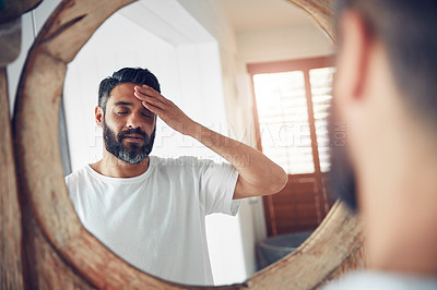 Buy stock photo Stress, headache and man by a mirror in the bathroom while doing a skincare routine in his home. Migraine, tired and mature male person doing a health dermatology face treatment in his modern house.