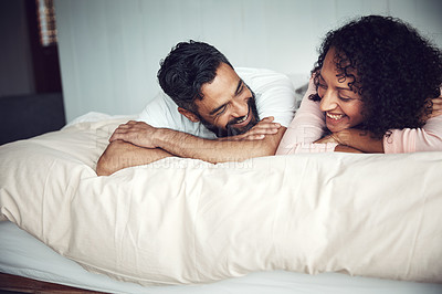 Buy stock photo Shot of a mature couple relaxing together on the bed at home