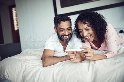 Buy stock photo Couple, smiling and bedroom with pregnancy test, positive and bed with happiness, results and excited. Man, woman and baby with stick, love and maternity for future family, surprise and pregnancy