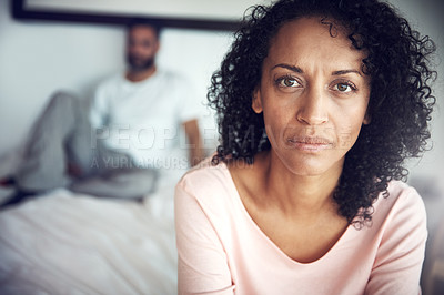 Buy stock photo Portrait of a mature woman looking upset with her husband in the background
