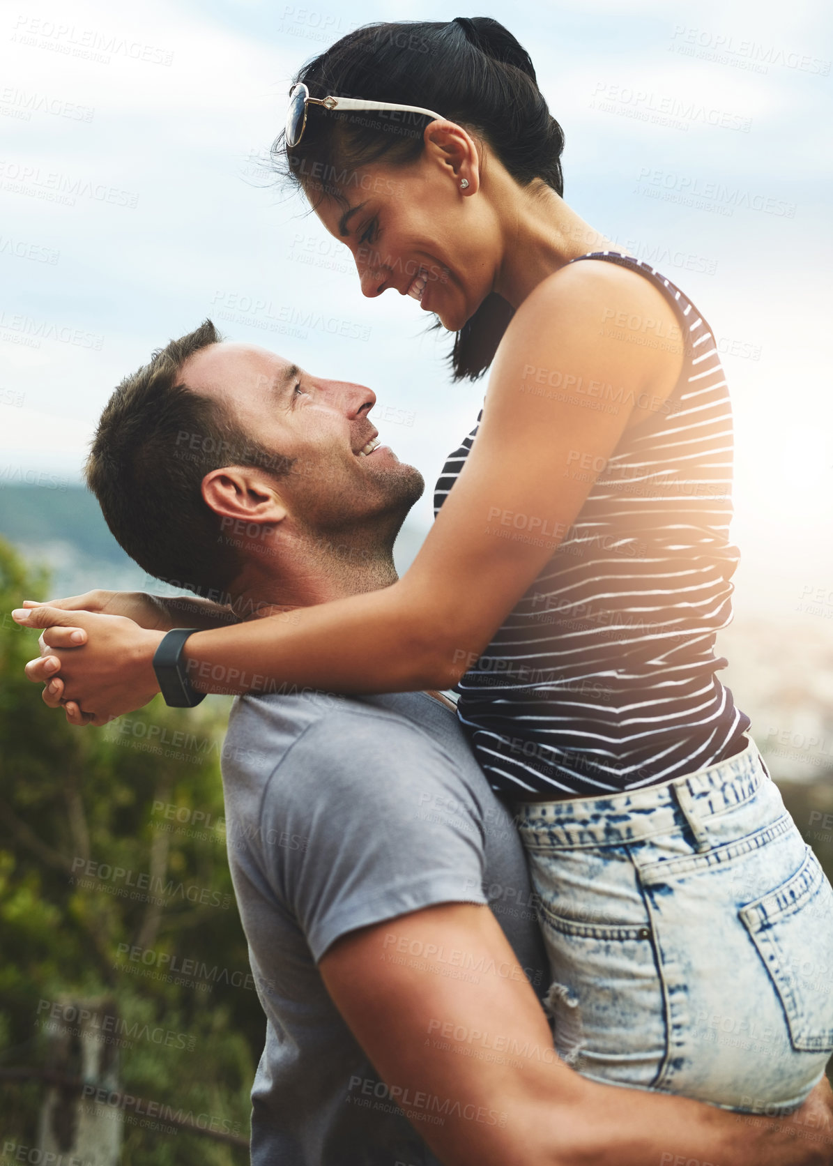 Buy stock photo Shot of a young couple enjoying a romantic day outdoors