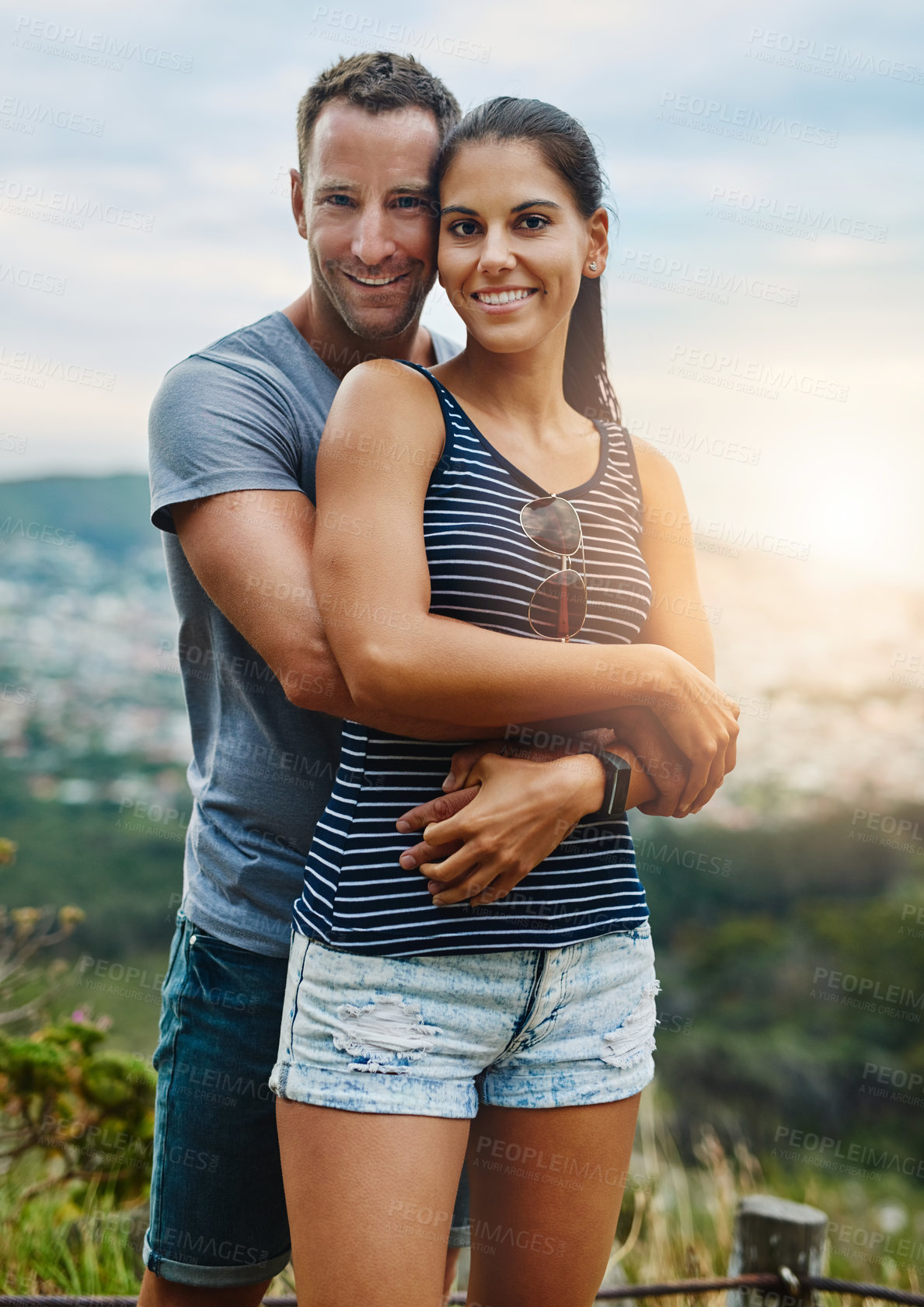 Buy stock photo Portrait, hug and couple with happiness, outdoor and lens flare with holiday, romance and vacation. Face, man and woman with bonding, adventure and health with fun, outside and wellness with love