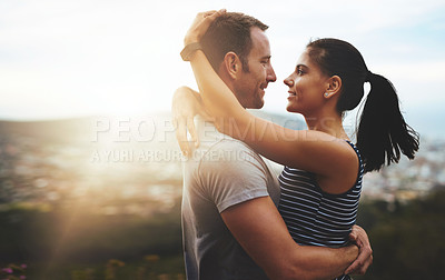 Buy stock photo Shot of a young couple in a loving embrace outdoors