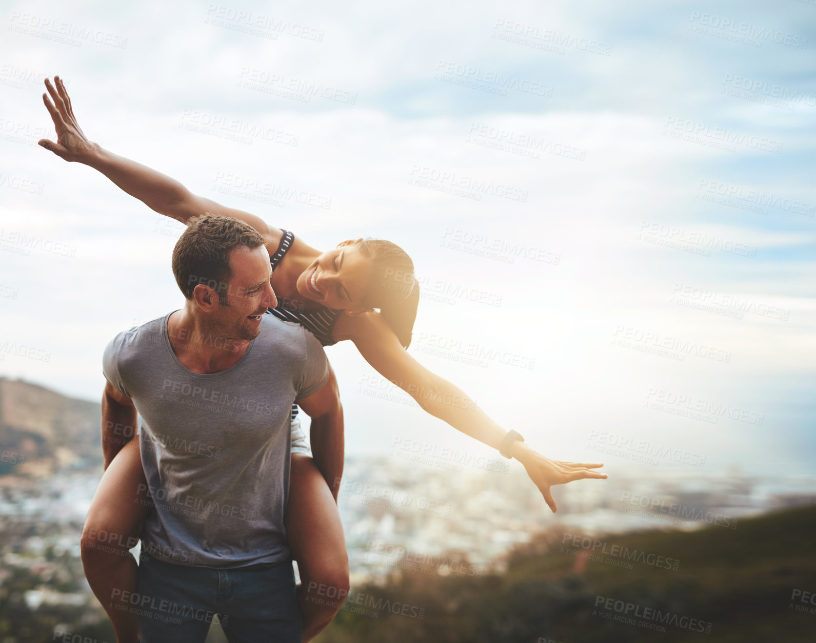 Buy stock photo Travel, happy couple with piggyback ride and mountain outdoors with lens flare. Sunshine or mockup space, nature adventure or freedom and people playing on holiday break or summer vacation together.